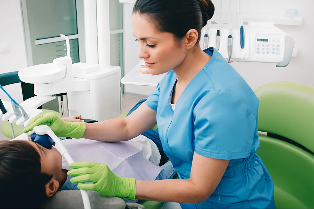 Dentist providing gentle sedation care to young patient